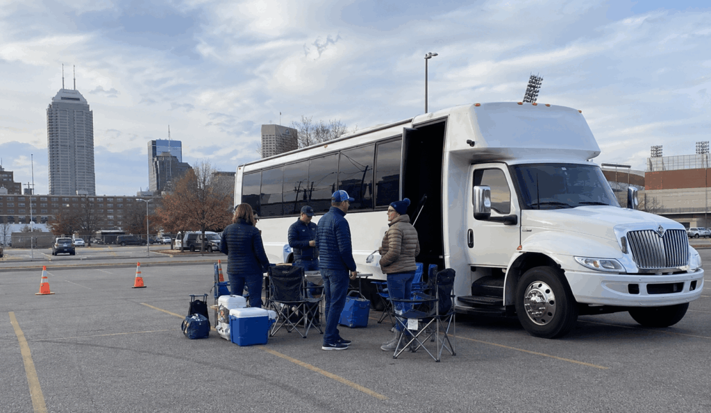 football fans gathering beside a white party bus before a colts tailgate in downtown indianapolis
