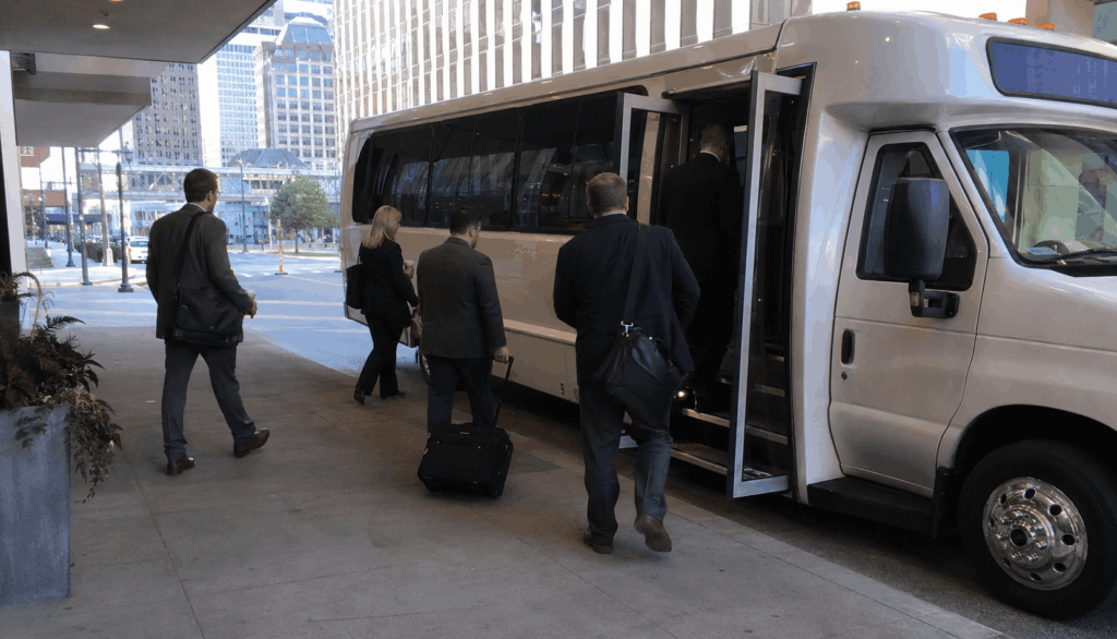 conference attendees boarding an unbranded shuttle bus at a downtown indianapolis hotel