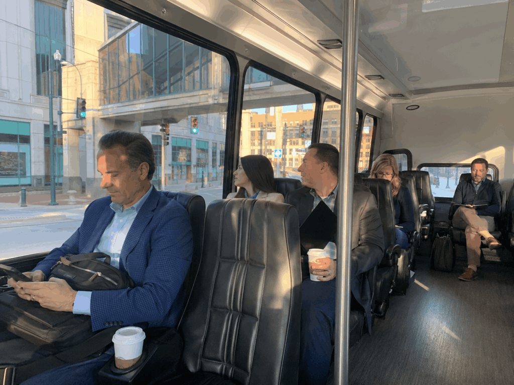 corporate group riding an indianapolis conference shuttle bus with laptops and event materials