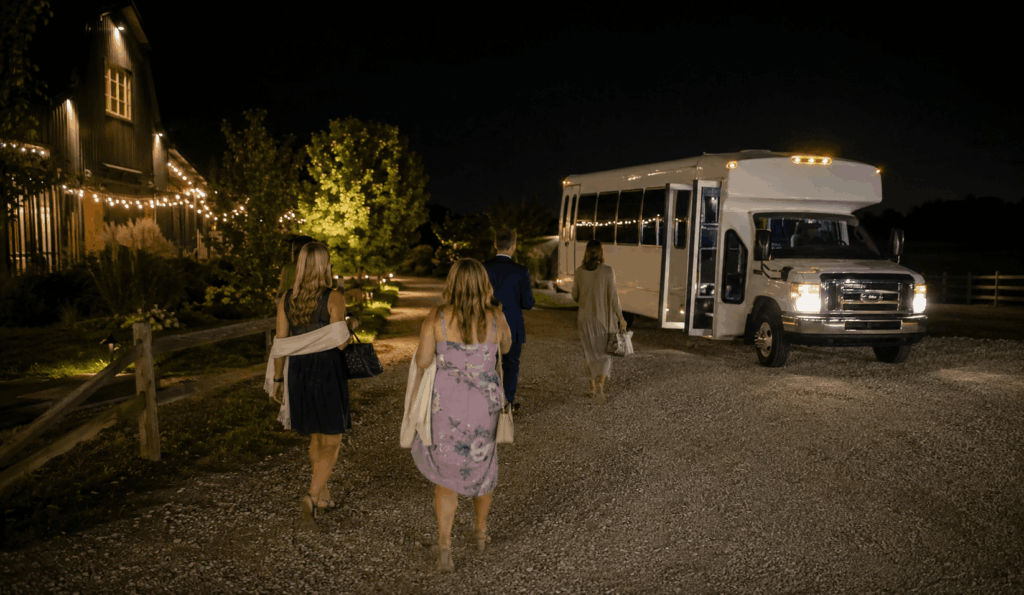 wedding guests boarding a shuttle bus at night after a rural barn wedding near Indianapolis